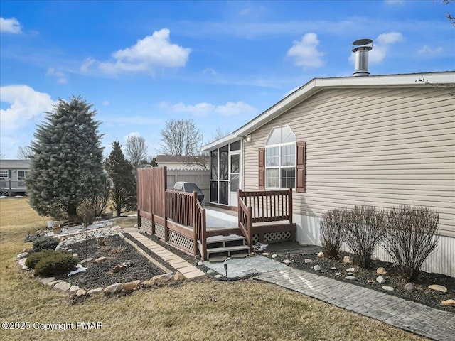 exterior space with a yard, a wooden deck, and a sunroom