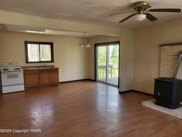 2153 Gravel Rd, Canadensis, PA 18325 - unfurnished living room featuring a textured ceiling, wood finished floors, a sink, and a wood stove