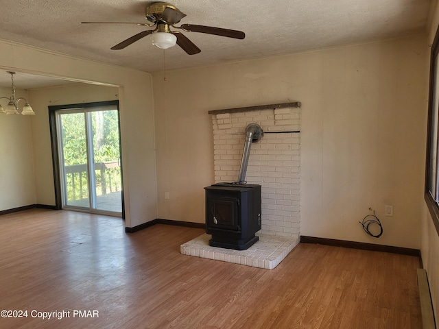 2153 Gravel Rd, Canadensis, PA 18325 - unfurnished living room with a wood stove, a textured ceiling, wood finished floors, and ceiling fan with notable chandelier