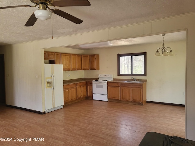 2153 Gravel Rd, Canadensis, PA 18325 - kitchen featuring brown cabinetry, light wood-style floors, a sink, a textured ceiling, and white appliances