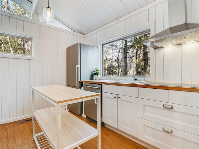 1109 Cedar Knoll Way, Pocono Pines, PA 18350 - kitchen featuring stainless steel dishwasher, wall chimney exhaust hood, lofted ceiling, light wood-type flooring, and white cabinetry