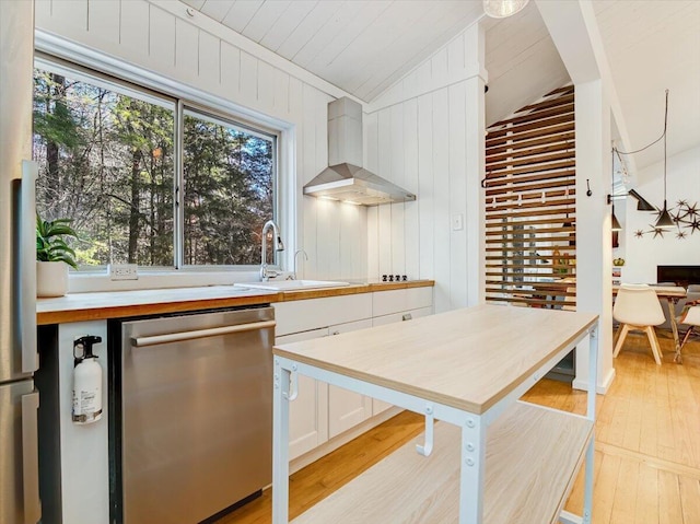 1109 Cedar Knoll Way, Pocono Pines, PA 18350 - kitchen featuring stainless steel dishwasher, wall chimney exhaust hood, light wood-type flooring, vaulted ceiling, and white cabinetry