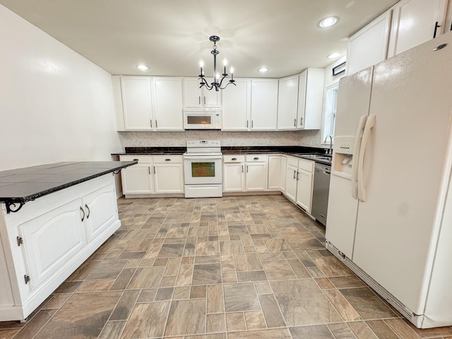 kitchen with white cabinetry, dark countertops, a sink, and white appliances
