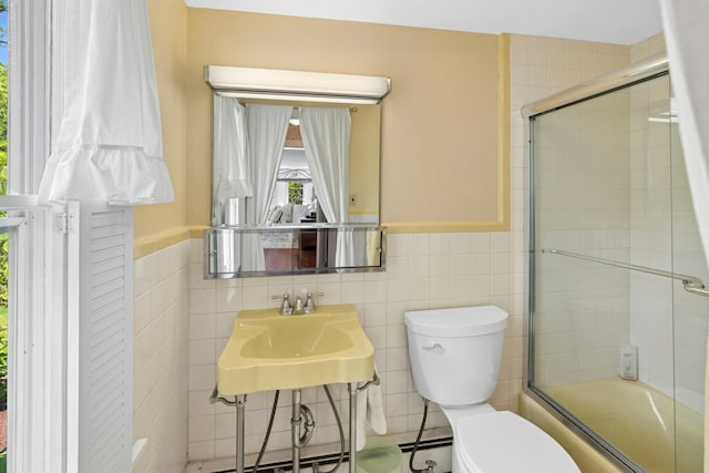 282 Crabapple Ln, East Stroudsburg, PA 18302 - bathroom with tile walls, bath / shower combo with glass door, and wainscoting