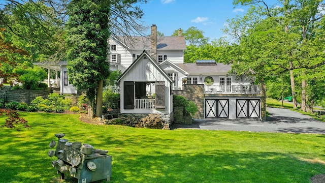 282 Crabapple Ln, East Stroudsburg, PA 18302 - back of property with a garage, board and batten siding, a lawn, asphalt driveway, and a chimney