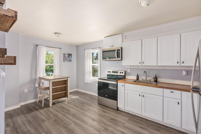 490 Richmond Rd, Bangor, PA 18013 - kitchen featuring appliances with stainless steel finishes, a sink, butcher block counters, light wood-style flooring, and white cabinetry