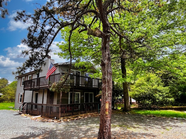 view of front of house featuring a chimney and a wooden deck