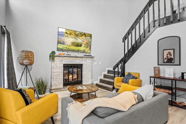 1150 Country Place Dr, Tobyhanna, PA 18466 - living room with stairway, a high ceiling, wood finished floors, a brick fireplace, and baseboards