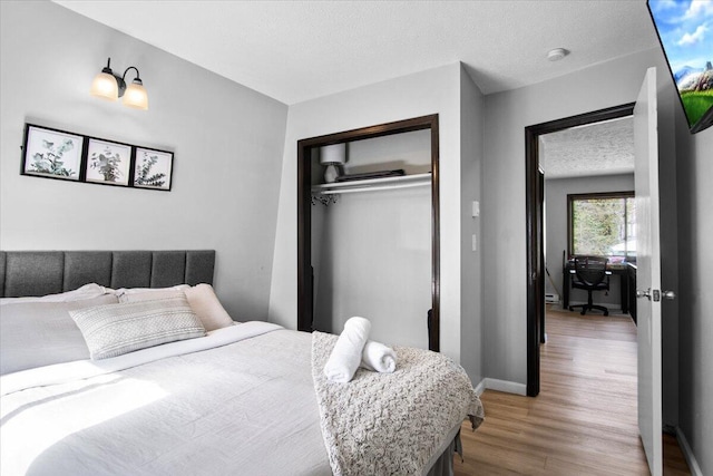 1150 Country Place Dr, Tobyhanna, PA 18466 - bedroom featuring baseboards, a closet, wood finished floors, and a textured ceiling