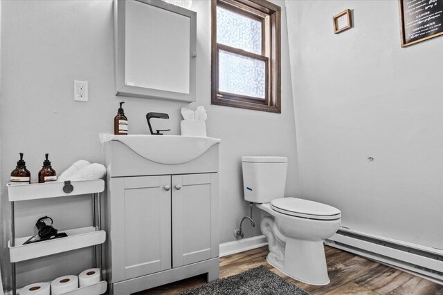 1150 Country Place Dr, Tobyhanna, PA 18466 - half bath featuring a baseboard radiator, baseboards, wood finished floors, toilet, and vanity