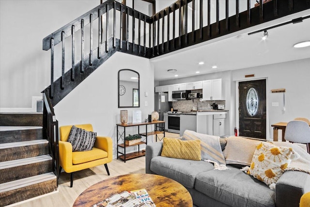 1150 Country Place Dr, Tobyhanna, PA 18466 - living room with stairs, a high ceiling, light wood-style floors, and baseboards
