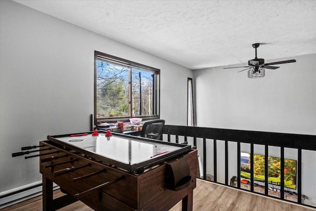 1150 Country Place Dr, Tobyhanna, PA 18466 - recreation room featuring ceiling fan, wood finished floors, a baseboard heating unit, and a textured ceiling
