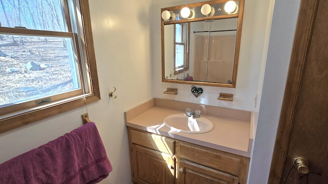 bathroom with a shower with door and vanity