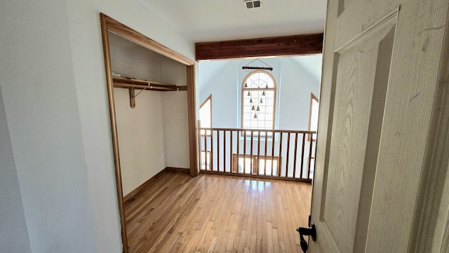 hall with visible vents, lofted ceiling with beams, and hardwood / wood-style flooring