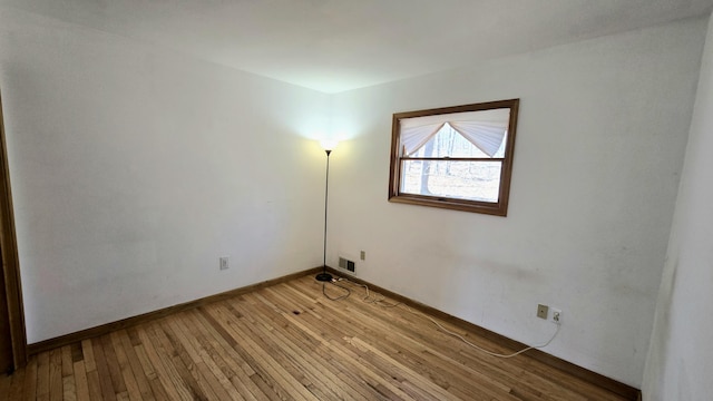 spare room with visible vents, light wood-style floors, and baseboards