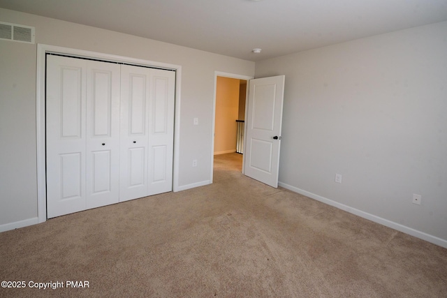 unfurnished bedroom featuring carpet flooring, baseboards, visible vents, and a closet