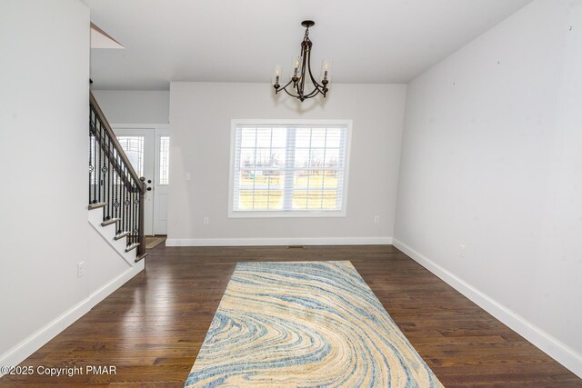 interior space with an inviting chandelier and dark hardwood / wood-style flooring