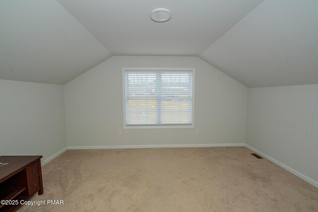 bonus room with light colored carpet and lofted ceiling