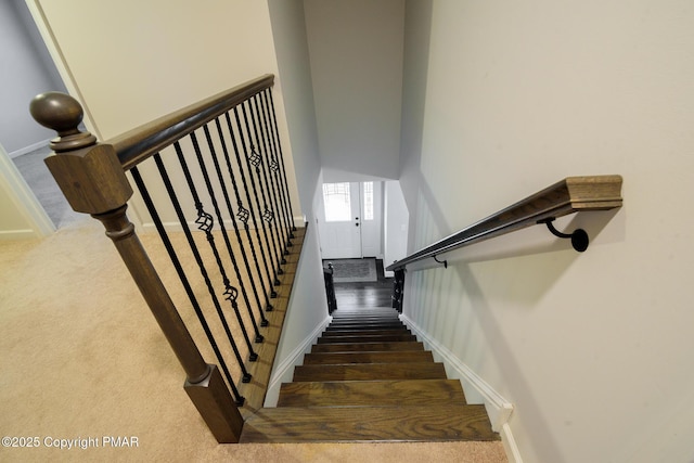 staircase with baseboards and carpet flooring