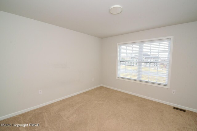 unfurnished room featuring light colored carpet