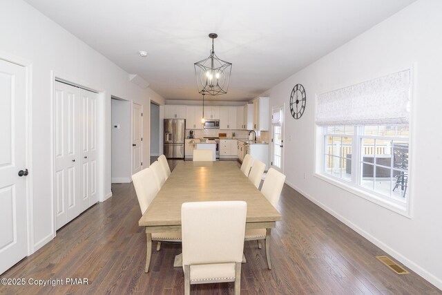 dining area featuring an inviting chandelier, dark hardwood / wood-style floors, and sink