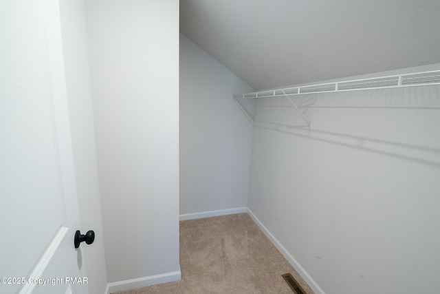 walk in closet featuring visible vents and light carpet