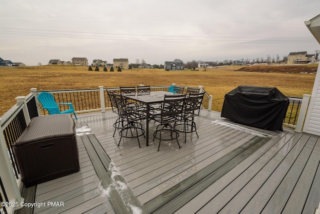 wooden deck featuring area for grilling, a rural view, and outdoor dining area