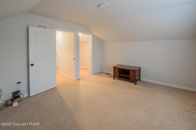 bonus room featuring lofted ceiling and light colored carpet