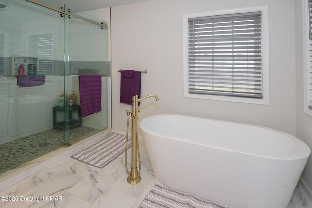 full bathroom featuring a soaking tub, marble finish floor, and a shower stall