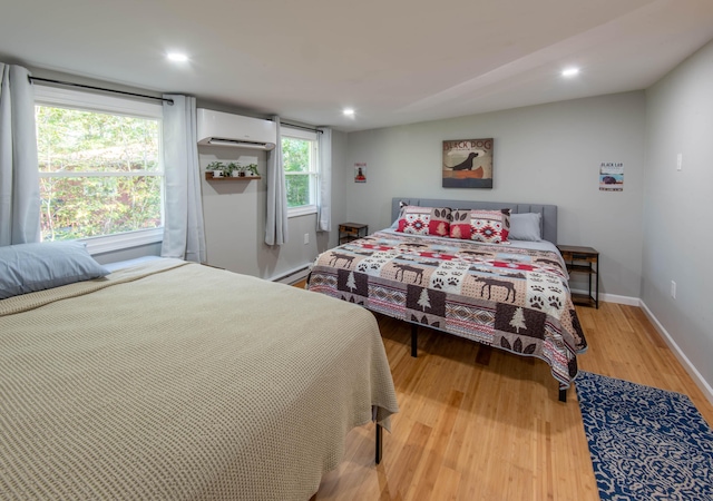 115 Squaw Trl, Pocono Lake, PA 18347 - bedroom featuring a wall unit AC, a baseboard heating unit, wood finished floors, and recessed lighting