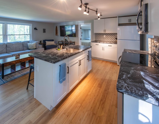 115 Squaw Trl, Pocono Lake, PA 18347 - kitchen with stainless steel microwave, freestanding refrigerator, light wood finished floors, white cabinets, and backsplash