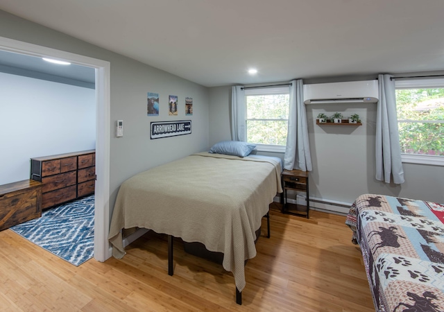 115 Squaw Trl, Pocono Lake, PA 18347 - bedroom featuring a wall unit AC, wood finished floors, a baseboard heating unit, multiple windows, and recessed lighting
