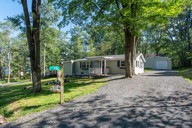 115 Squaw Trl, Pocono Lake, PA 18347 - view of front of home with an outbuilding, a front yard, a porch, gravel driveway, and a garage