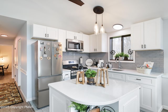 kitchen featuring a center island, white cabinetry, stainless steel appliances, and sink