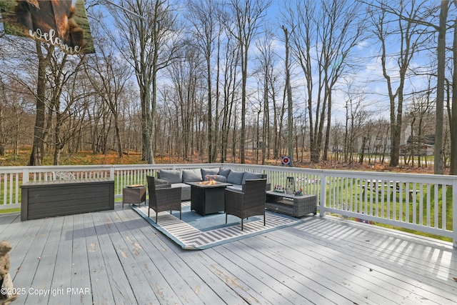 deck featuring an outdoor living space with a fire pit