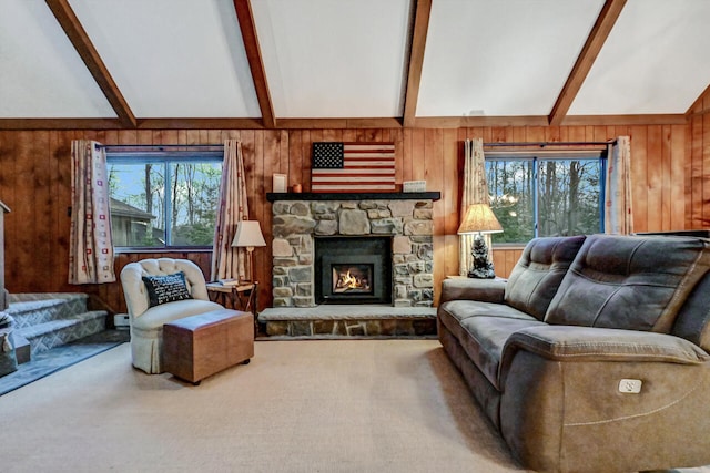 carpeted living area with lofted ceiling with beams, wooden walls, and a fireplace