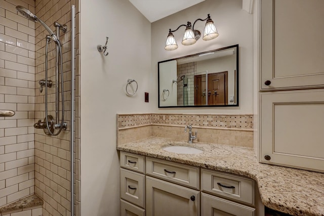 bathroom with a stall shower, vanity, and decorative backsplash