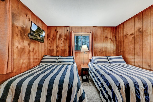 bedroom featuring carpet flooring and wooden walls