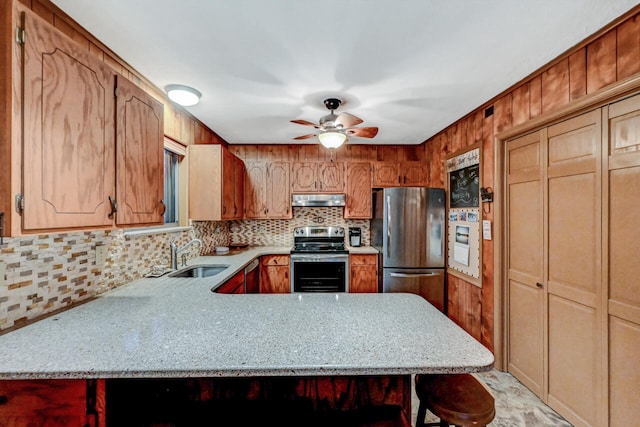 kitchen with decorative backsplash, appliances with stainless steel finishes, a ceiling fan, a sink, and under cabinet range hood