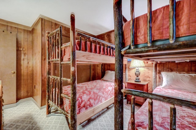 bedroom with carpet floors and wooden walls