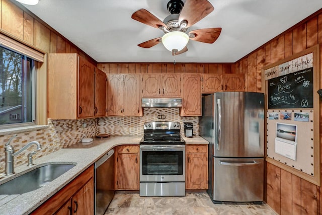 kitchen featuring stainless steel appliances, tasteful backsplash, a sink, and under cabinet range hood