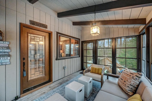 sunroom featuring wood ceiling and lofted ceiling with beams