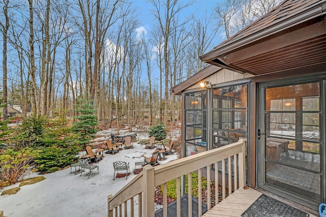 wooden deck featuring a patio and a sunroom