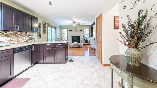 1154 Park Dr, East Stroudsburg, PA 18302 - kitchen with stainless steel dishwasher, a ceiling fan, a peninsula, a brick fireplace, and decorative backsplash
