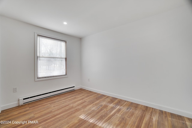 empty room featuring baseboards, recessed lighting, a baseboard radiator, and light wood-style floors