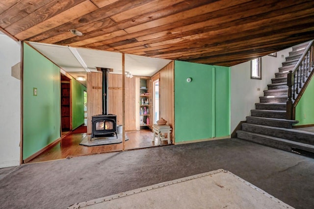 209 Cross St, Pocono Lake, PA 18347 - unfurnished living room featuring stairway, carpet, and a wood stove