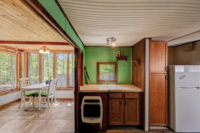 209 Cross St, Pocono Lake, PA 18347 - kitchen with freestanding refrigerator, wood ceiling, heating unit, light tile patterned flooring, and baseboards