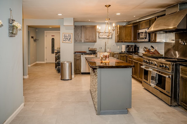2735 Rte 390, Canadensis, PA 18325 - kitchen with appliances with stainless steel finishes, exhaust hood, baseboards, a chandelier, and a kitchen island