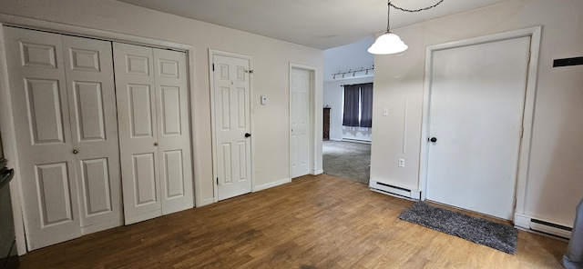 8934 Deerfield Rd, Tobyhanna, PA 18466 - unfurnished bedroom featuring a baseboard heating unit, wood finished floors, and two closets