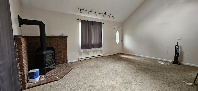 8934 Deerfield Rd, Tobyhanna, PA 18466 - unfurnished living room with baseboard heating, carpet flooring, track lighting, a wood stove, and lofted ceiling